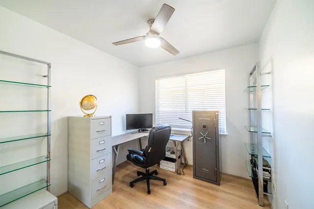 a view of a workspace with furniture and a window