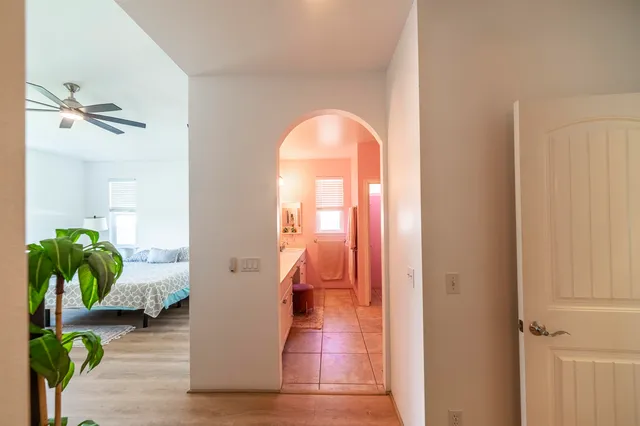 a view of a hallway with wooden floor and a chandelier