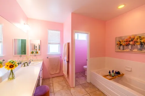 a spacious bathroom with a tub sink and mirror