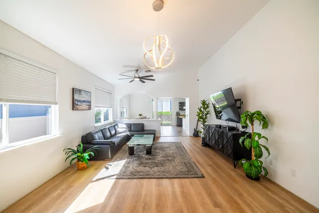 a living room with furniture floor to ceiling window and potted plant