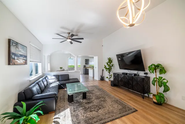 a living room with furniture a flat screen tv and a potted plant