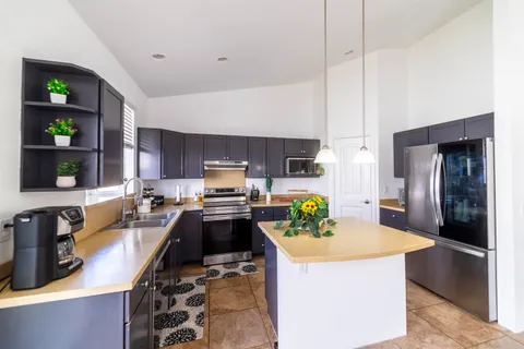 a kitchen with stainless steel appliances a stove a refrigerator a sink a counter space and cabinets
