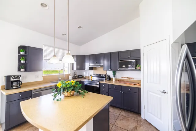 a kitchen with stainless steel appliances granite countertop a sink a stove and refrigerator