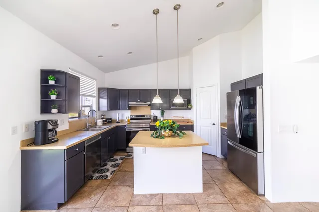 a kitchen with a sink counter top space and stainless steel appliances
