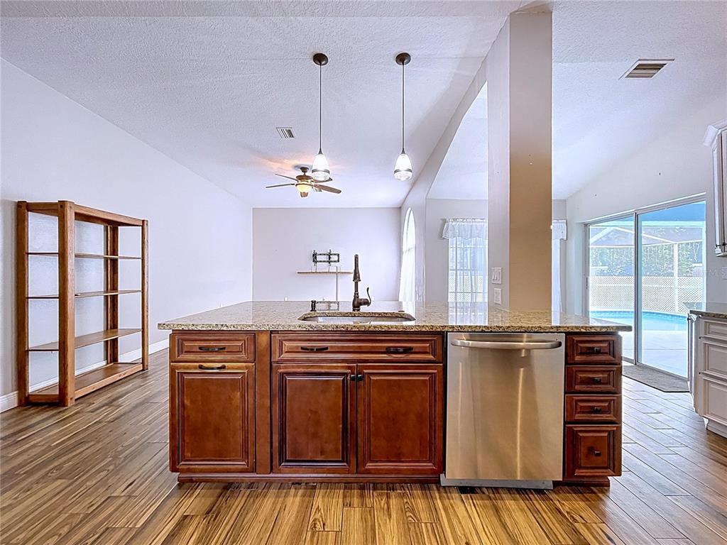 18812 Bascomb Lane Hudson, FL 34667 - Photo 29 of 57 a kitchen with kitchen island granite countertop a stove cabinets and wooden floor