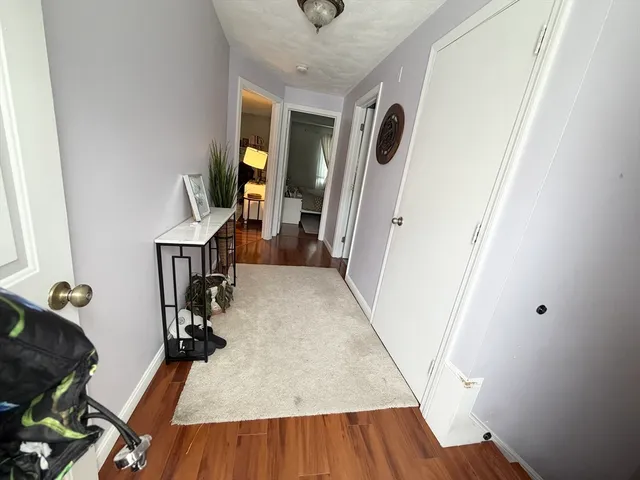 a view of a hallway with wooden floor and stairs