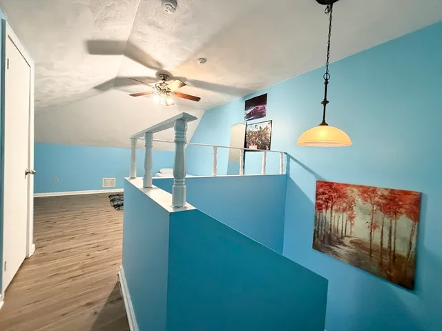 a room with a chandelier fan and a rug