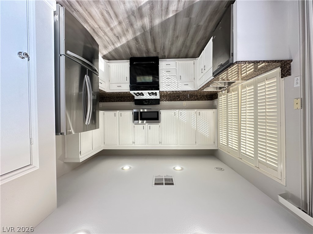 10191 Splendor Ridge Avenue Las Vegas, NV 89135 - Photo 5 of 31 A well-equipped kitchen features bright white cabinetry and sleek stainless steel appliances, ready for culinary endeavors.