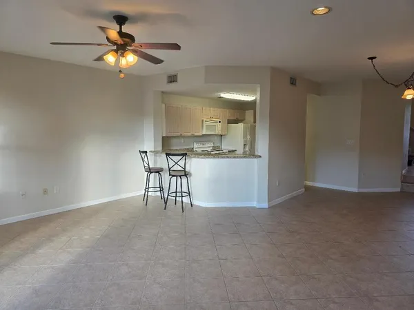 a view of a livingroom and a chandelier a kitchen