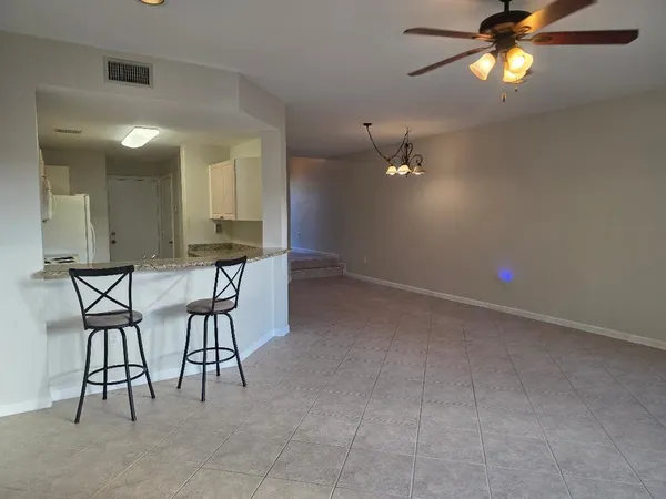 a view of a livingroom with furniture and chandelier fan