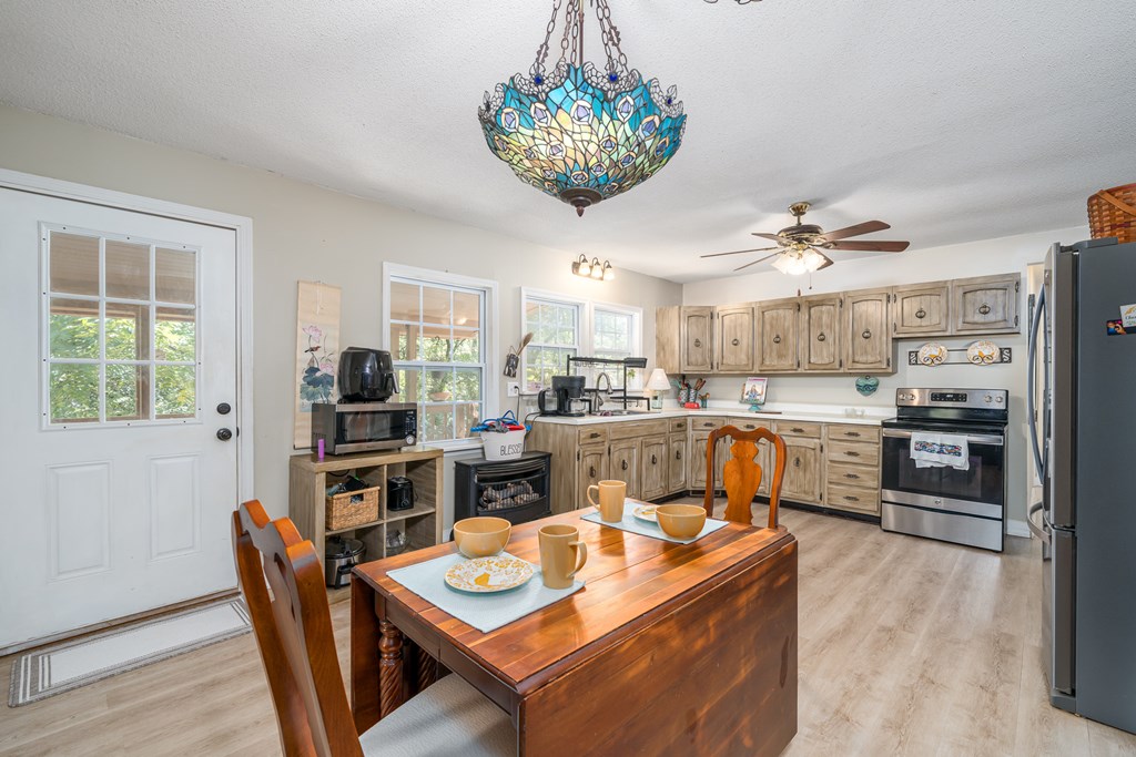 1813 John Smith Road East Blairsville, GA 30512 - Photo 5 of 41 a kitchen with stainless steel appliances kitchen island granite countertop a table chairs sink and cabinets