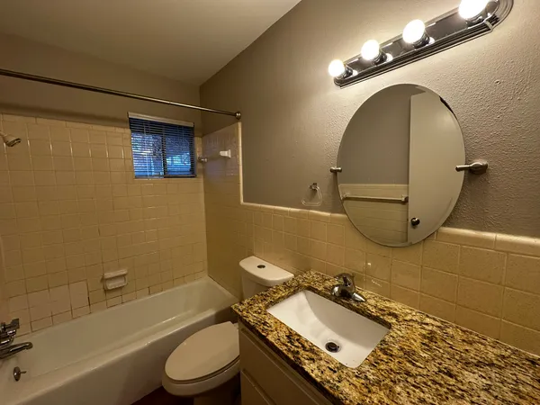 a bathroom with a sink mirror vanity and toilet