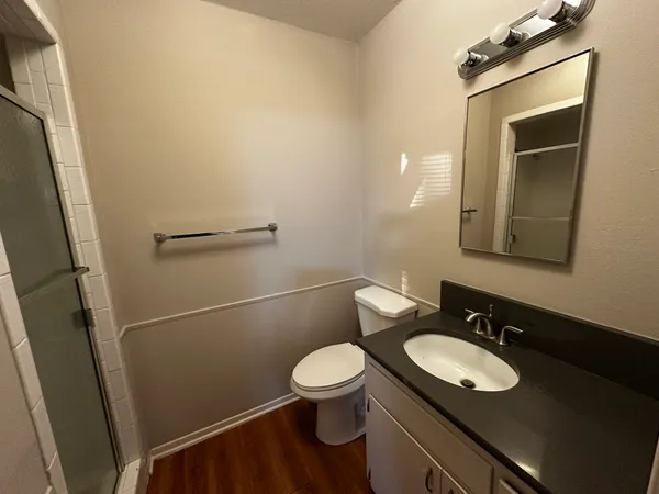 a bathroom with a granite countertop sink toilet a mirror and a shower