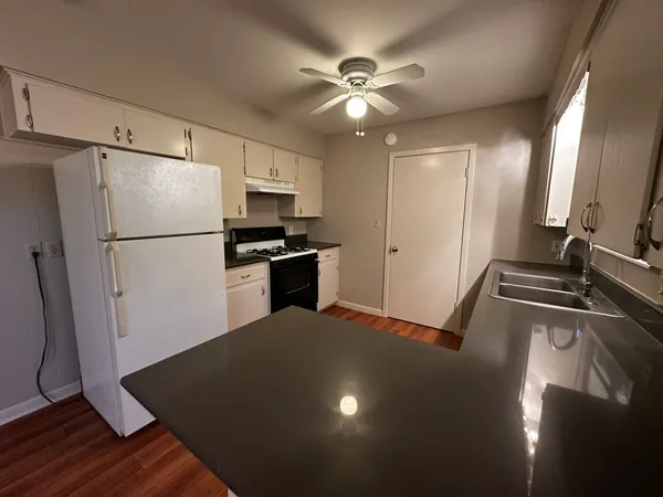 a kitchen with a refrigerator and a stove top oven