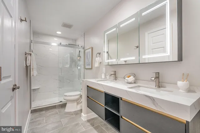 a bathroom with a sink a toilet and shower