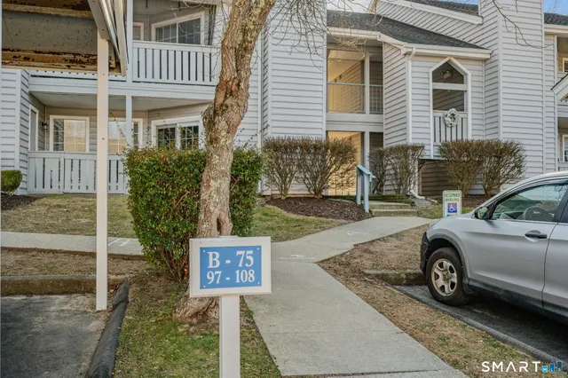 a car parked in front of a white house