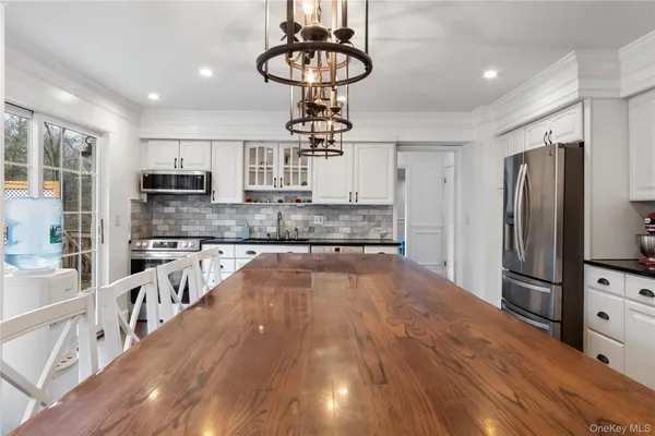 a large kitchen with kitchen island a large counter space appliances and cabinets