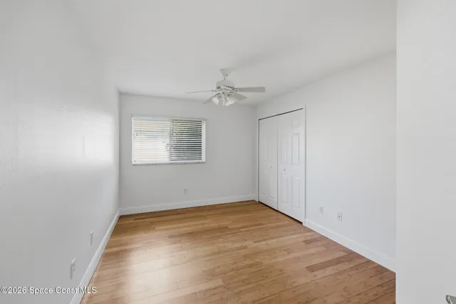an empty room with a ceiling fan and window
