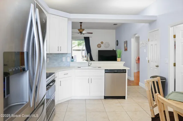 a kitchen with a refrigerator sink and white cabinets