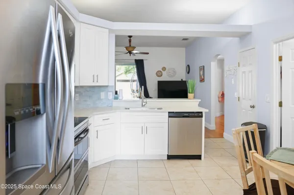 a kitchen with a refrigerator sink and white cabinets