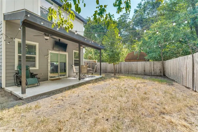 a view of a backyard with a tub and wooden fence