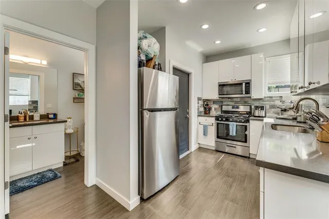 a kitchen with a refrigerator a stove top oven a sink and cabinets