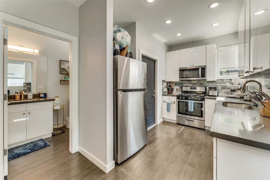 4709 Prock Lane, Unit B Austin, TX 78721 - Photo 6 of 17 a kitchen with a refrigerator a stove top oven a sink and cabinets