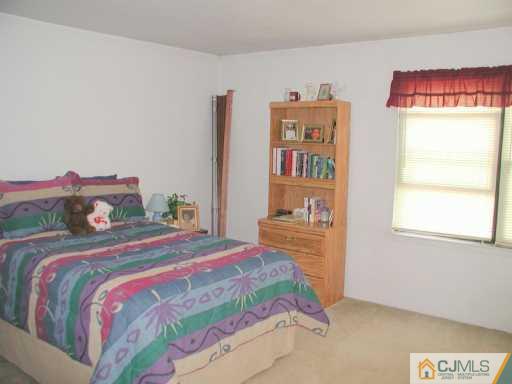 7005 Hana Road Edison, NJ 08817 - Photo 6 of 8 a bedroom with a bed and a book shelf