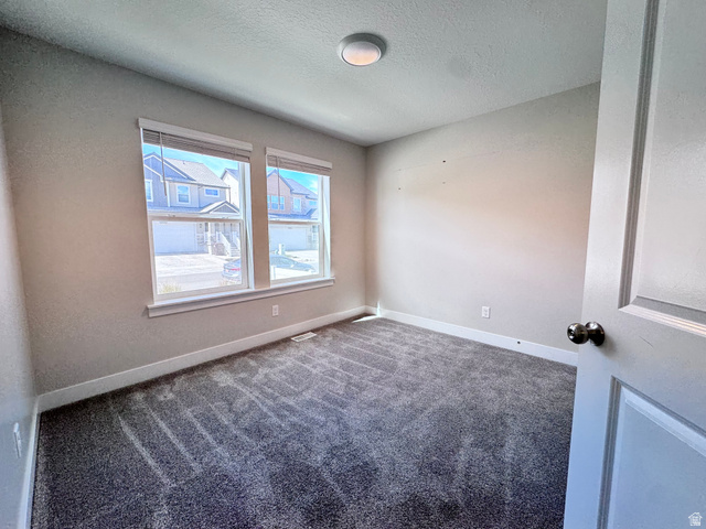 12339 Remy Road, Unit 422 Herriman, UT 84096 - Photo 4 of 36 Empty room featuring carpet flooring and a textured ceiling