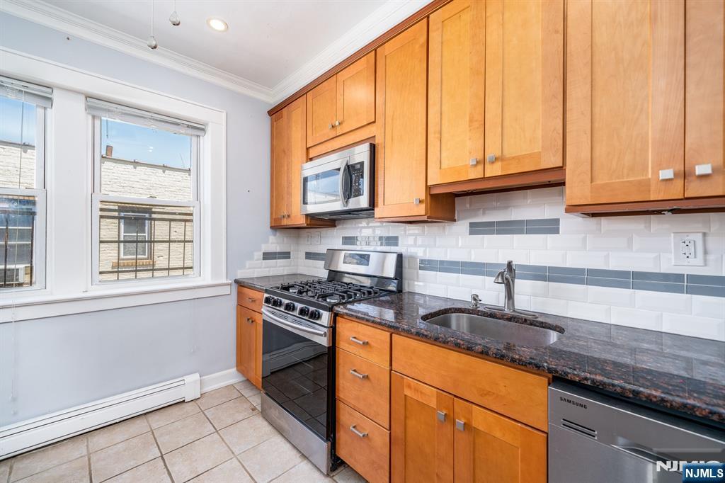 82 Hackensack Street, Unit 3 Wood-Ridge, NJ 07075 - Photo 2 of 19 a kitchen with stainless steel appliances granite countertop a sink a stove and a microwave