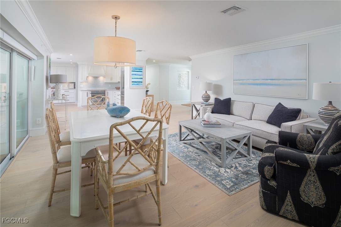 635 Fountainhead Lane Naples, FL 34103 - Photo 11 of 28 a living room with furniture and a chandelier