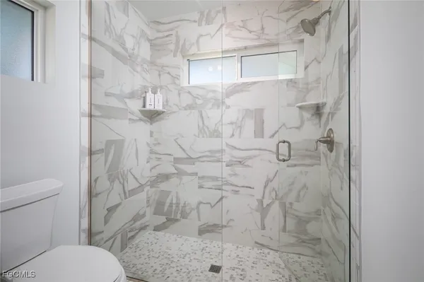 a bathroom with a toilet and a shower