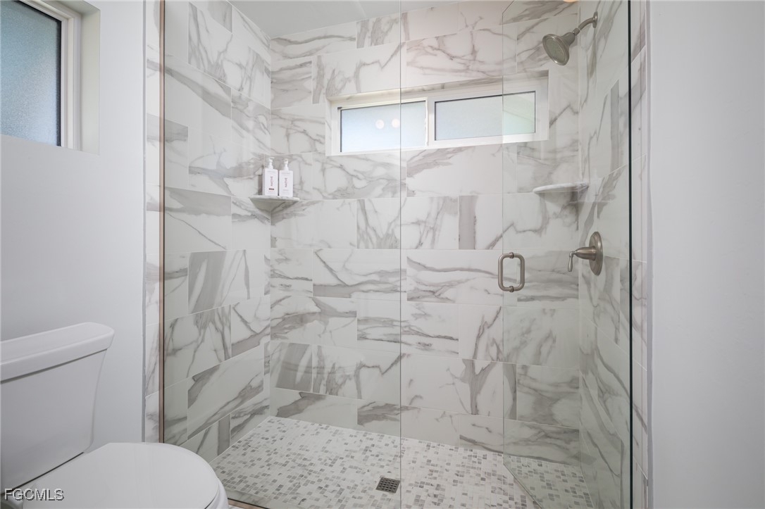635 Fountainhead Lane Naples, FL 34103 - Photo 17 of 28 a bathroom with a toilet and a shower