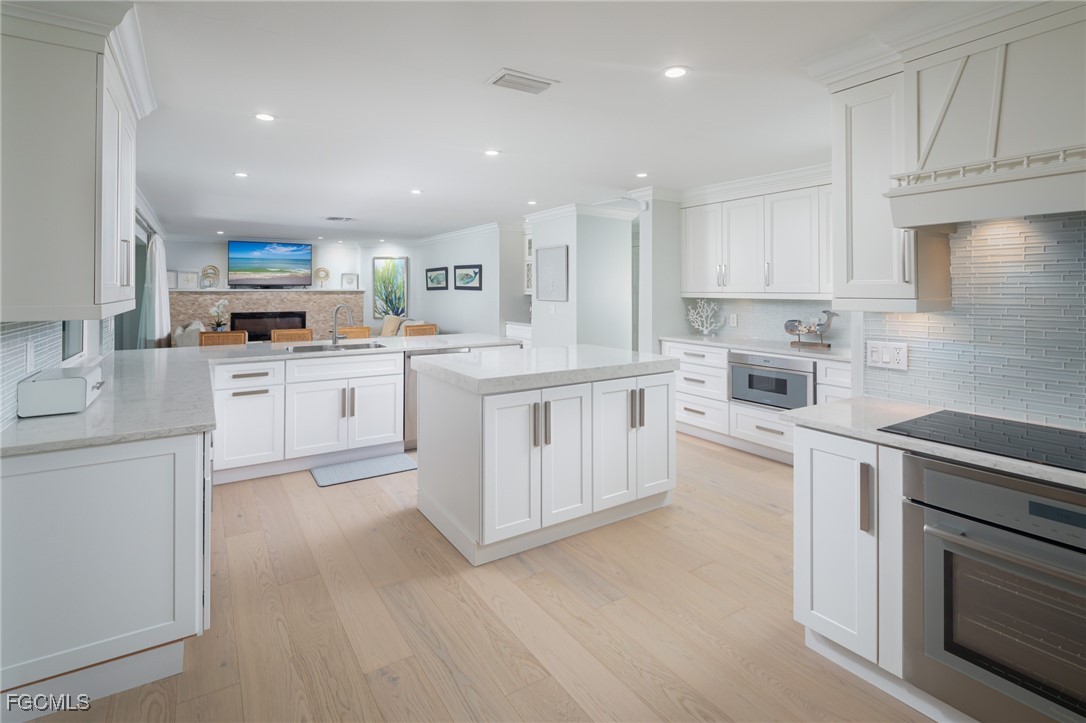 635 Fountainhead Lane Naples, FL 34103 - Photo 2 of 28 a kitchen with cabinets a sink and a stove top oven