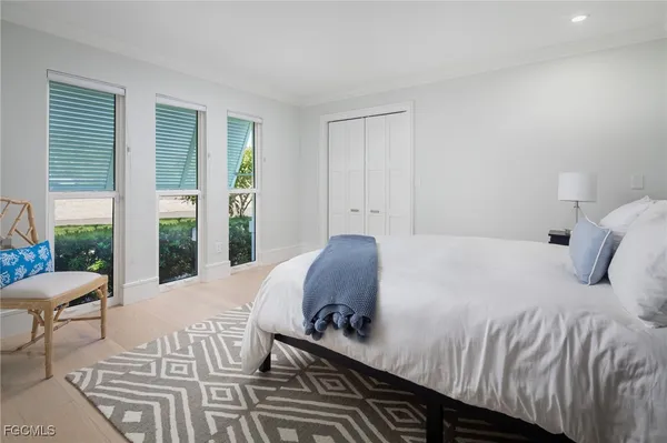 a bedroom with a bed and a large window