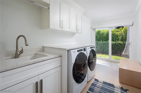 a utility room with sink dryer and washer