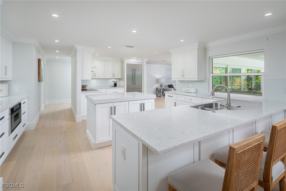 635 Fountainhead Lane Naples, FL 34103 - Photo 8 of 28 a large kitchen with stainless steel appliances a sink a stove a refrigerator and cabinets