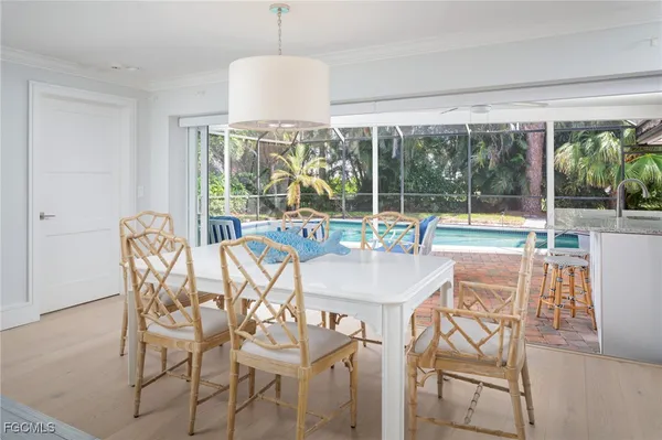 a view of a dining room with furniture large windows and wooden floor