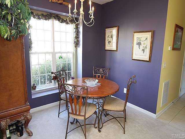 8333 Tie Stone Way Raleigh, NC 27613 - Photo 5 of 12 a dining room with furniture a rug and a floor to ceiling window