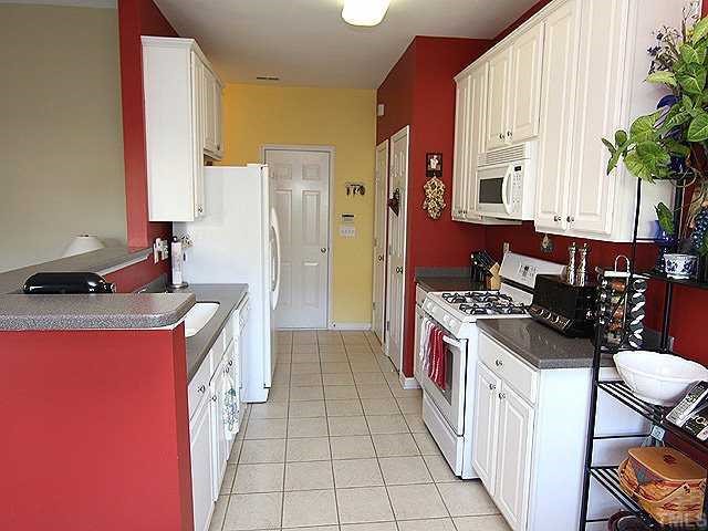 8333 Tie Stone Way Raleigh, NC 27613 - Photo 6 of 12 a kitchen with stainless steel appliances granite countertop a stove top oven a sink a counter space and cabinets