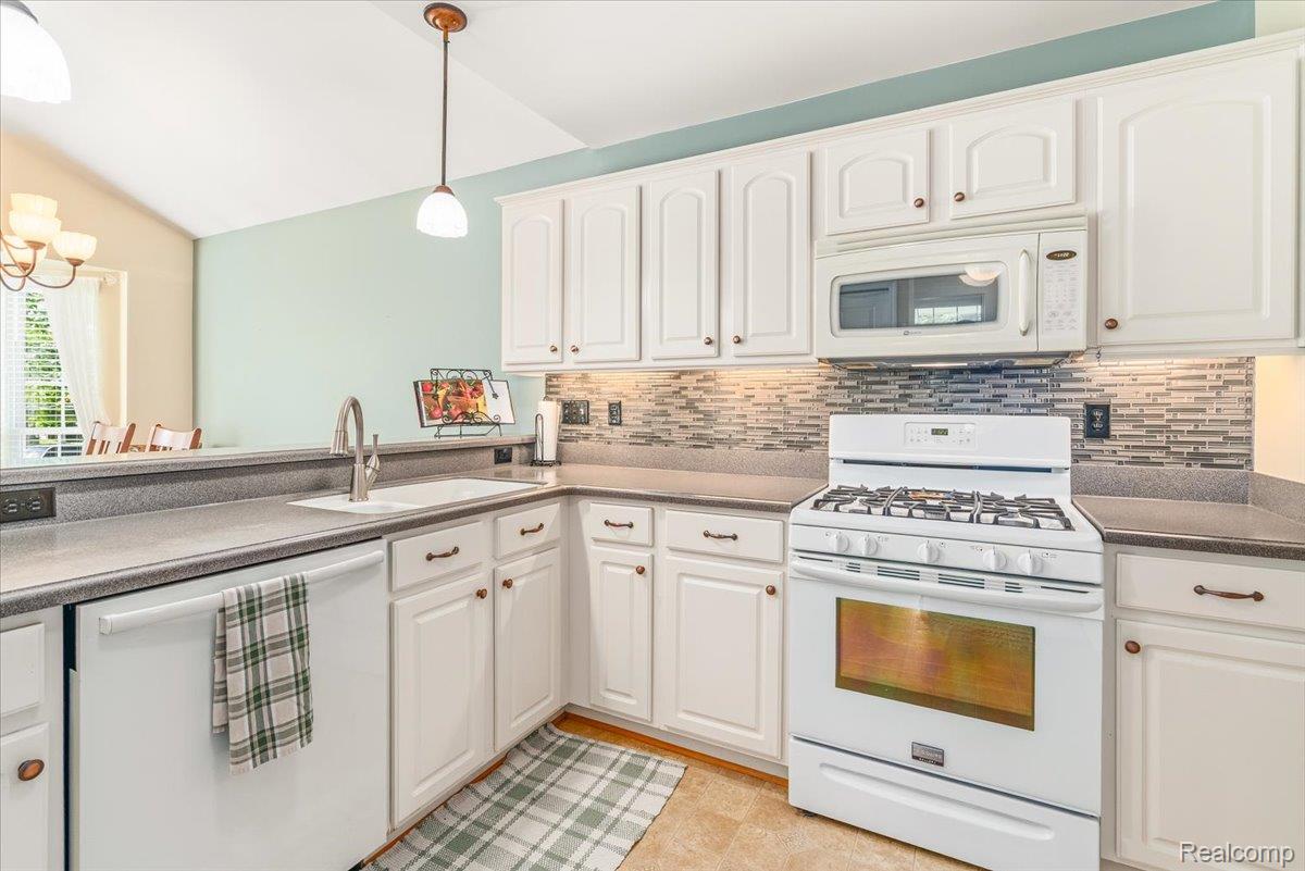 49105 Hawksburry Road Canton, MI 48188 - Photo 13 of 51 Kitchen featuring white cabinetry, grey countertops, a mosaic tile backsplash, a white gas range, and a built-in microwave