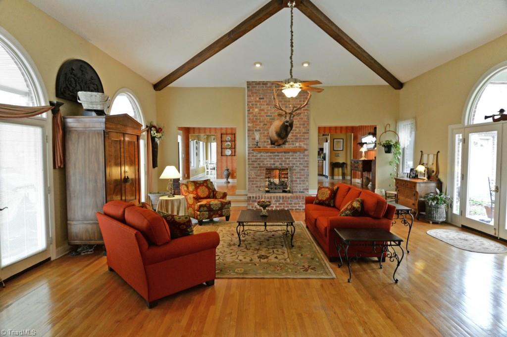 7437 Strawberry Road Summerfield, NC 27358 - Photo 14 of 27 Dramatic great room. Enter into this fabulous spacious room with beam vaulted ceiling and floor-to-ceiling gas log fireplace with raised hearth.