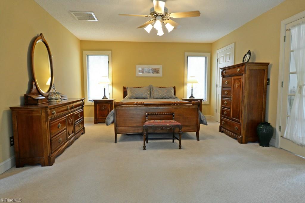 7437 Strawberry Road Summerfield, NC 27358 - Photo 22 of 27 The main level master bedroom. View is from the sunroom looking in.