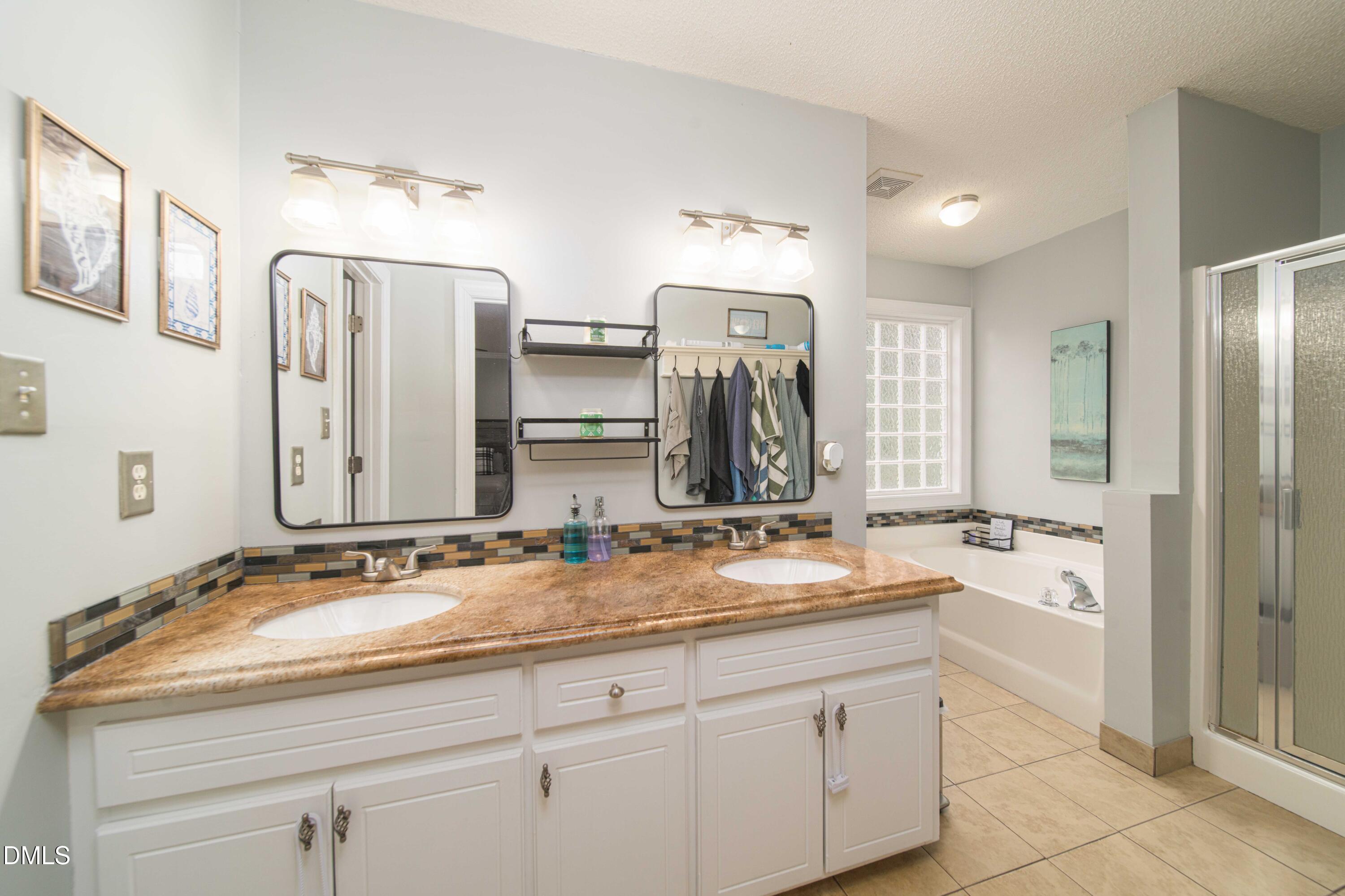 4411 Lessie Trail Rocky Mount, NC 27804 - Photo 13 of 27 a bathroom with double vanity sinks double vanity tub shower and a mirror