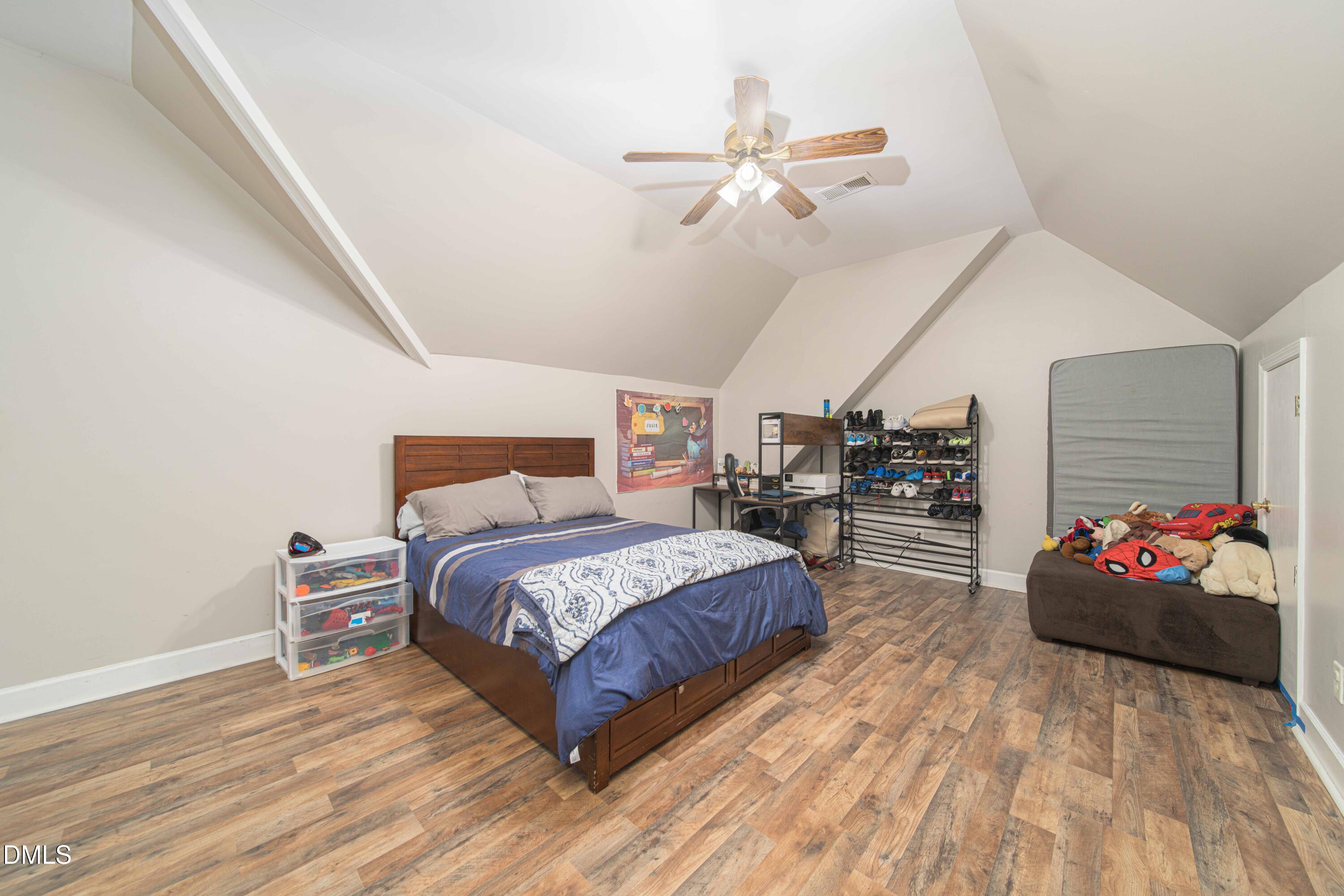 4411 Lessie Trail Rocky Mount, NC 27804 - Photo 21 of 27 a spacious bedroom with a bed and a chandelier