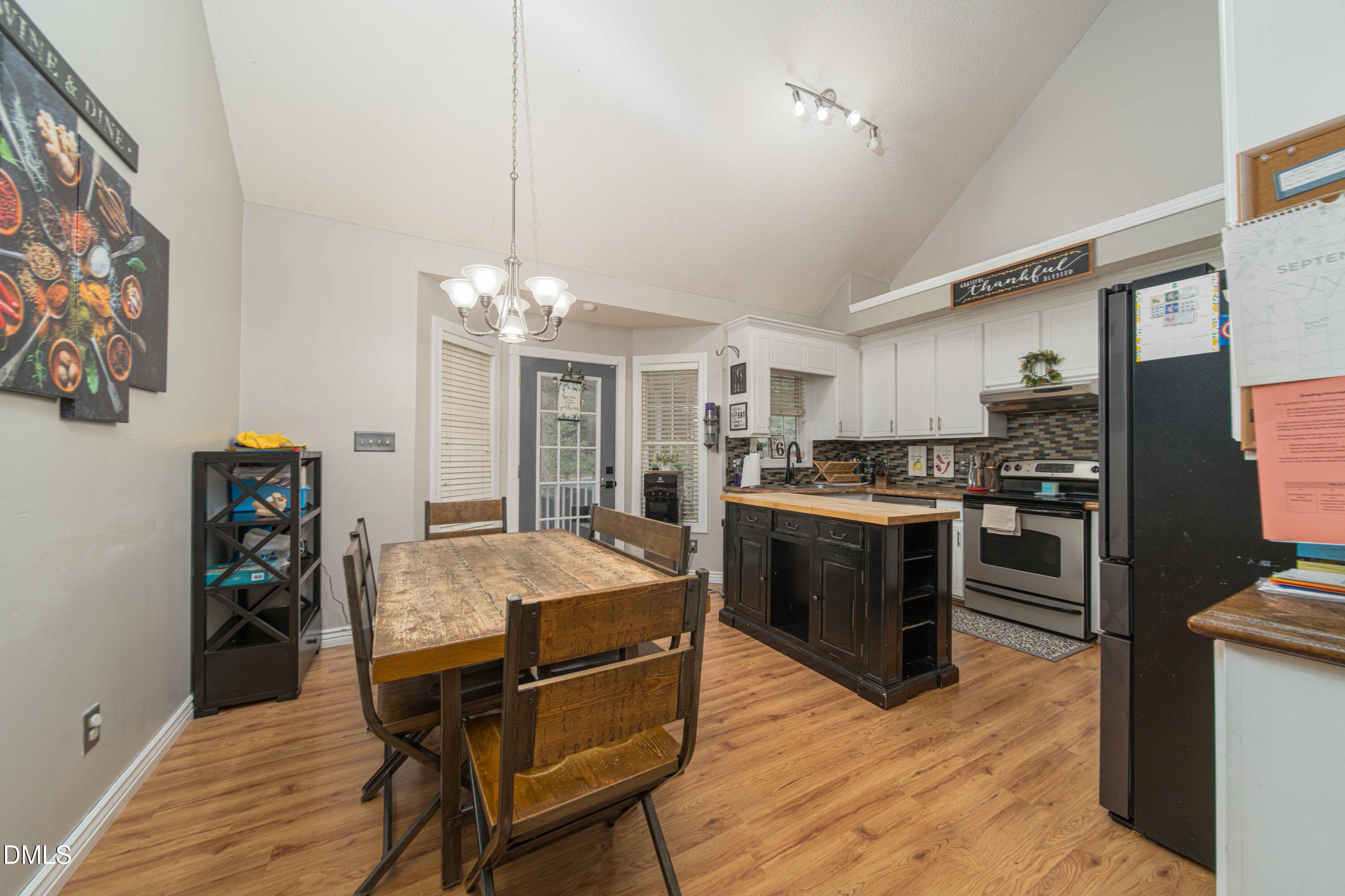 4411 Lessie Trail Rocky Mount, NC 27804 - Photo 6 of 27 a kitchen with refrigerator a stove and chairs