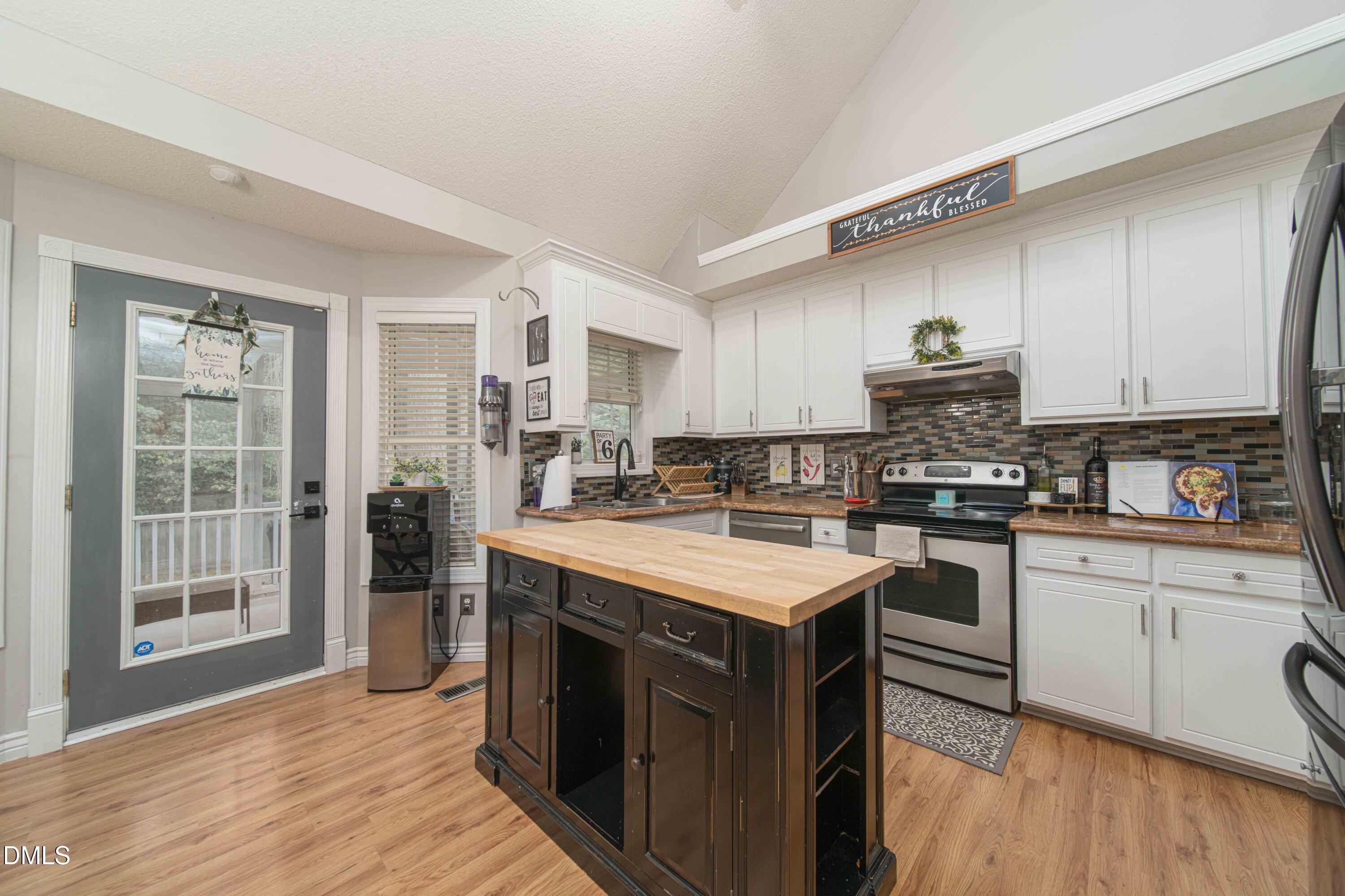 4411 Lessie Trail Rocky Mount, NC 27804 - Photo 7 of 27 a kitchen with stainless steel appliances a sink a stove a refrigerator cabinets and a window