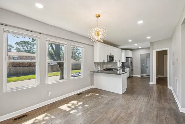 a large kitchen with kitchen island a large window in it
