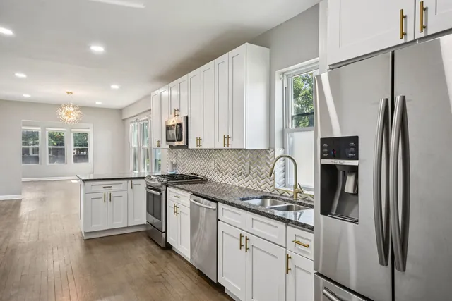 a kitchen with stainless steel appliances granite countertop a refrigerator sink and stove
