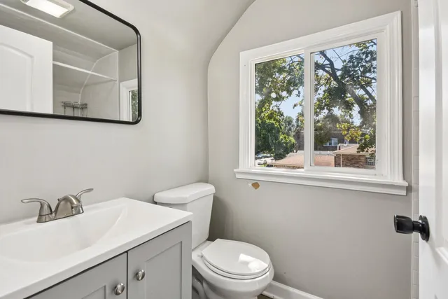 a bathroom with a toilet sink and mirror